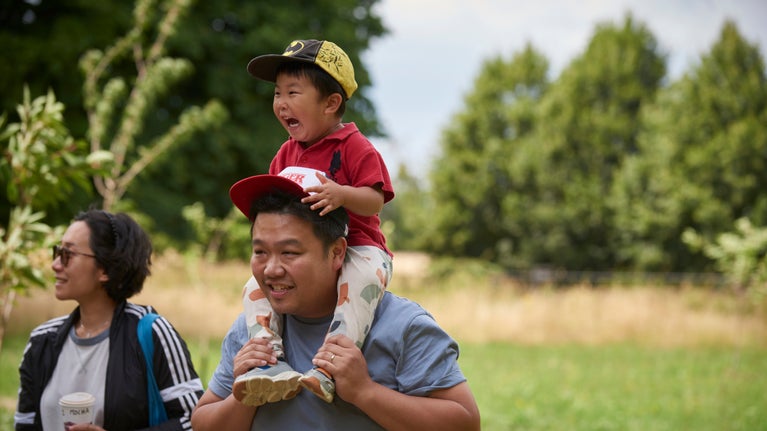 A lady and man with a small boy on his shoulders on a family day out at Polesden Lacey, Surrey